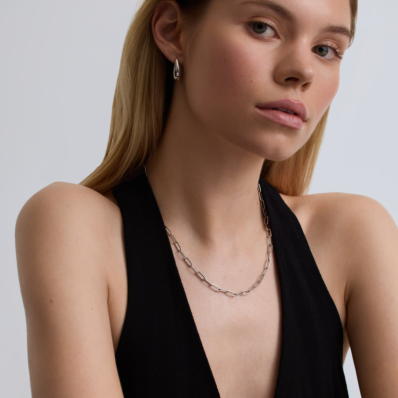 Woman wearing a black halter top with a plain background